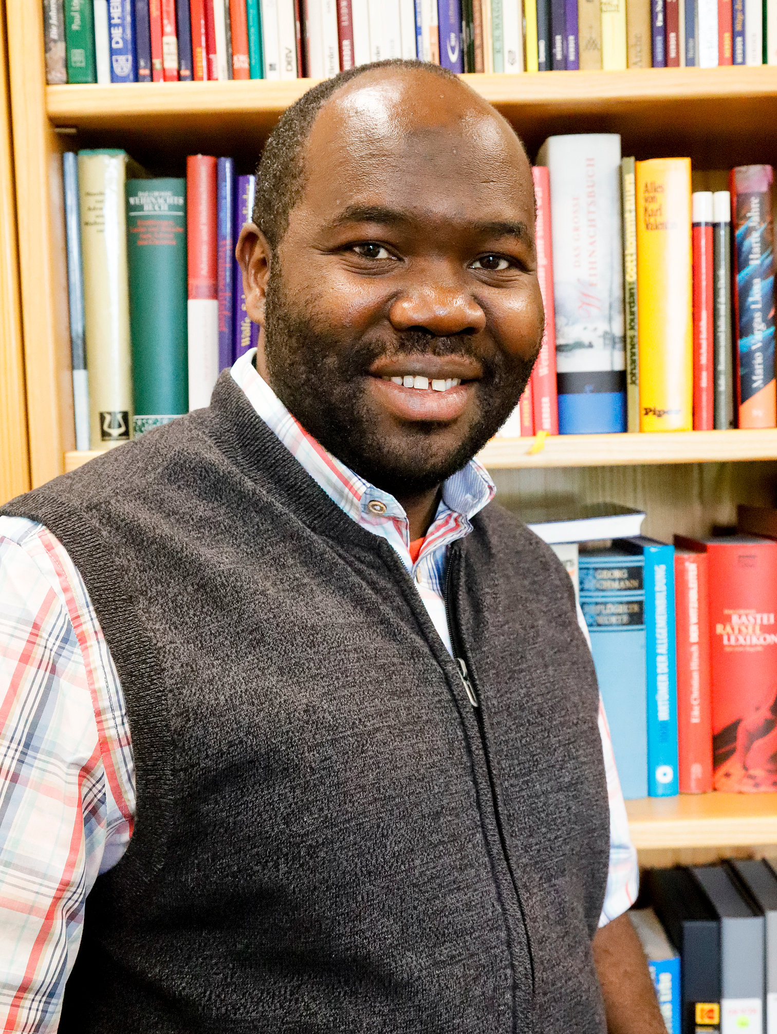 P. DEOGRATIAS NGUONZI, 46 Pater Deogratias Nguonzi vor einem Bücherregal